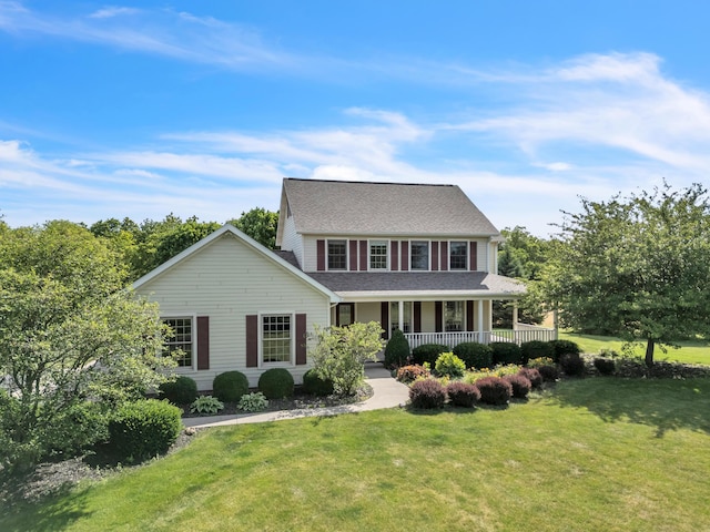 colonial inspired home with a porch and a front lawn