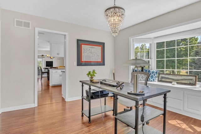 home office featuring a chandelier and light wood-type flooring