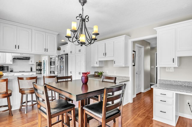 dining space featuring a chandelier and light wood-type flooring