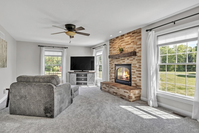 carpeted living room with a brick fireplace and ceiling fan