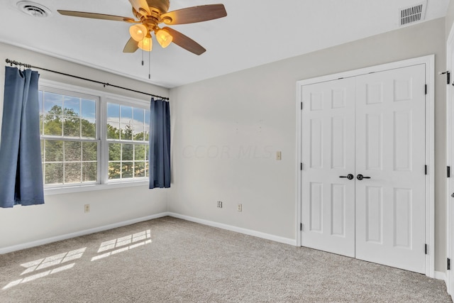 carpeted spare room with ceiling fan