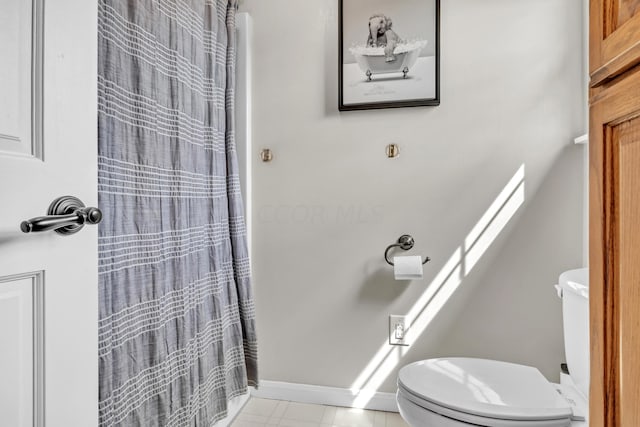 bathroom with curtained shower and toilet