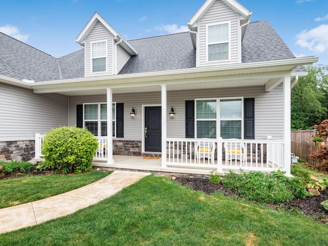 cape cod-style house featuring a porch and a front lawn