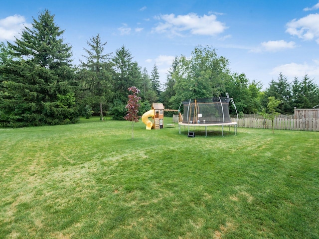 view of yard with a playground and a trampoline