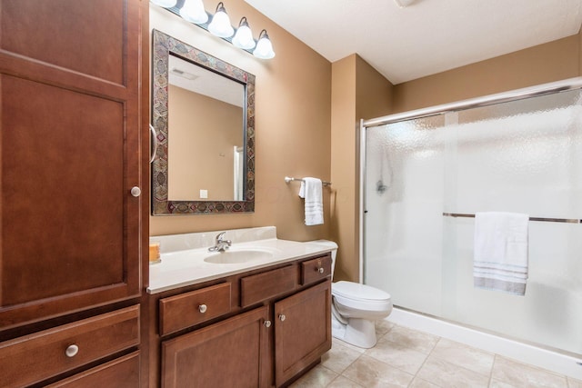 bathroom featuring toilet, vanity, tile patterned floors, and an enclosed shower