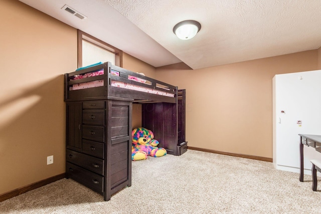 bedroom with light carpet and a textured ceiling