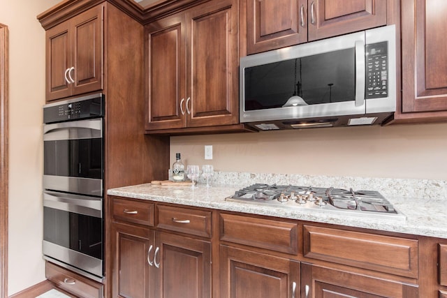 kitchen with light stone countertops and stainless steel appliances