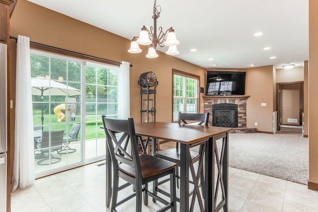 carpeted dining area with a notable chandelier and a fireplace