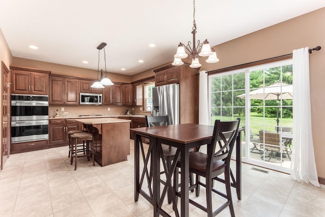 dining space with light tile patterned floors, sink, and a chandelier