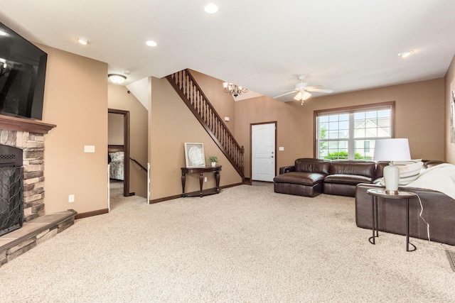 carpeted living room with ceiling fan and a fireplace