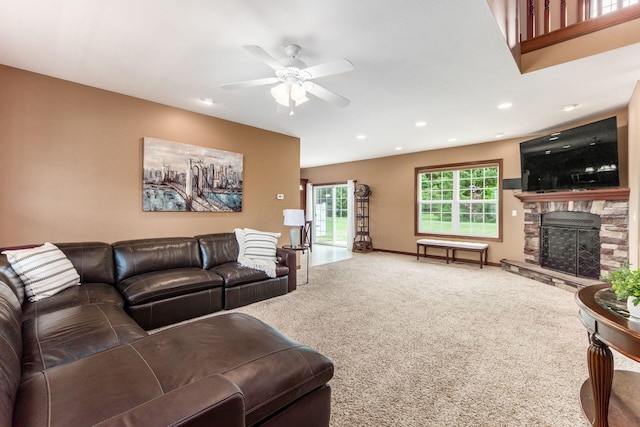 carpeted living room with ceiling fan and a fireplace