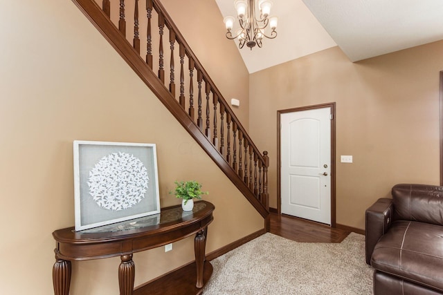 entrance foyer featuring carpet flooring, vaulted ceiling, and a notable chandelier