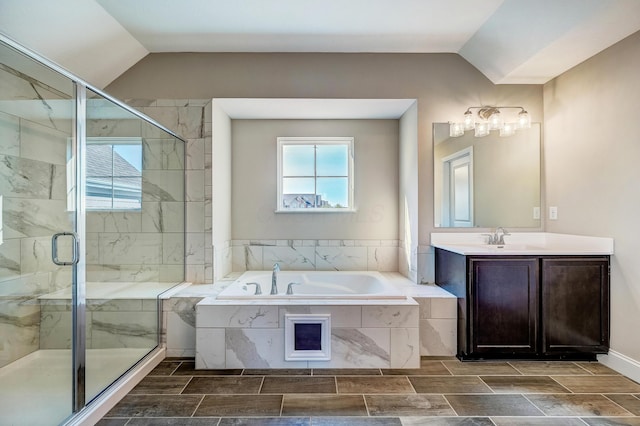 full bathroom featuring a stall shower, vaulted ceiling, a bath, and vanity