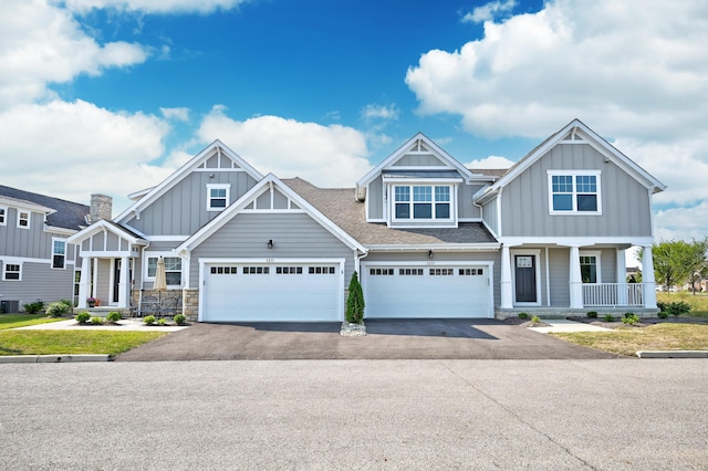 view of front of property featuring aphalt driveway, roof with shingles, covered porch, board and batten siding, and cooling unit