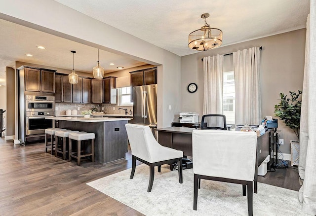 dining space featuring a notable chandelier, light wood finished floors, recessed lighting, and baseboards