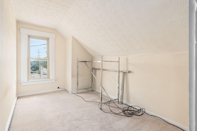 bonus room featuring lofted ceiling, a textured ceiling, and carpet