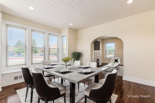 dining area with a textured ceiling and dark wood-type flooring