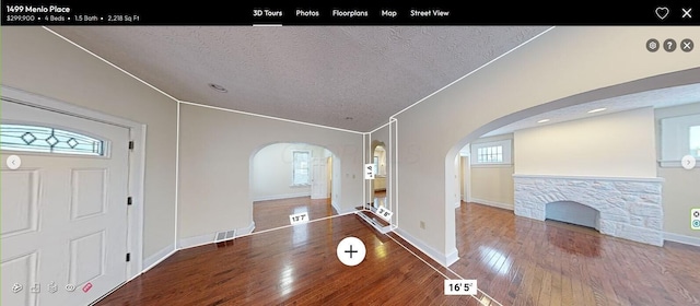 entryway with a textured ceiling, hardwood / wood-style floors, and ornamental molding