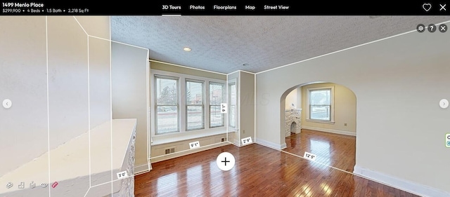 spare room with a textured ceiling and hardwood / wood-style floors