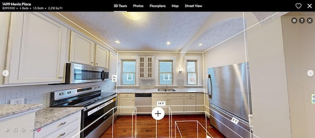 kitchen featuring white cabinets, stainless steel appliances, light stone countertops, and sink