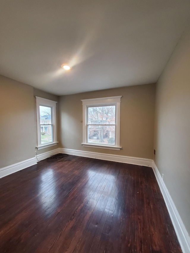 unfurnished room featuring dark hardwood / wood-style floors and a wealth of natural light