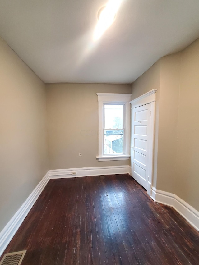 spare room with dark wood-type flooring