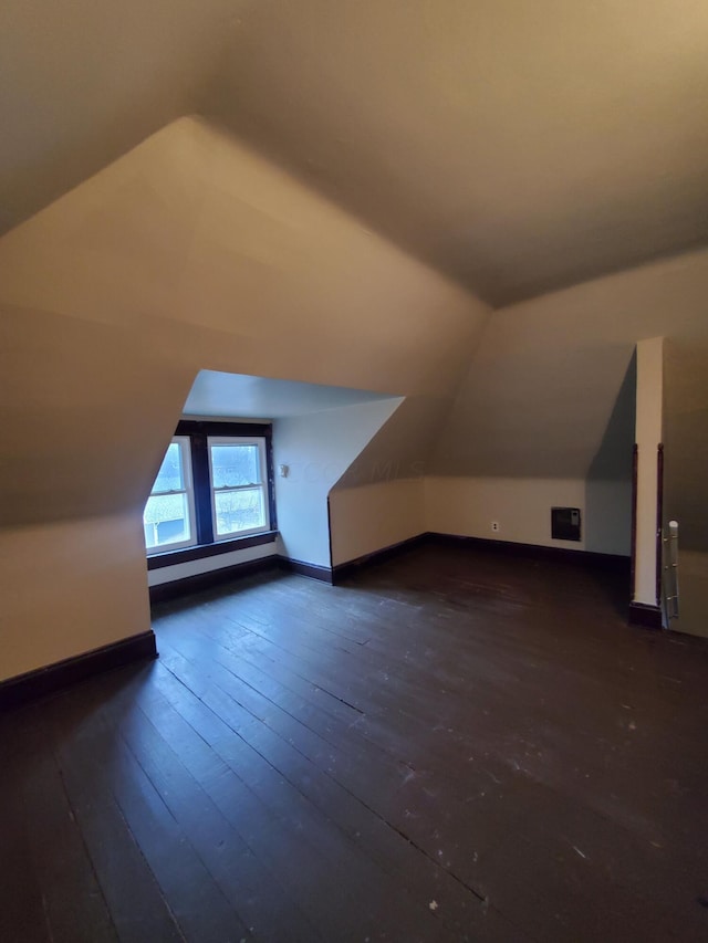 additional living space with dark hardwood / wood-style flooring and lofted ceiling