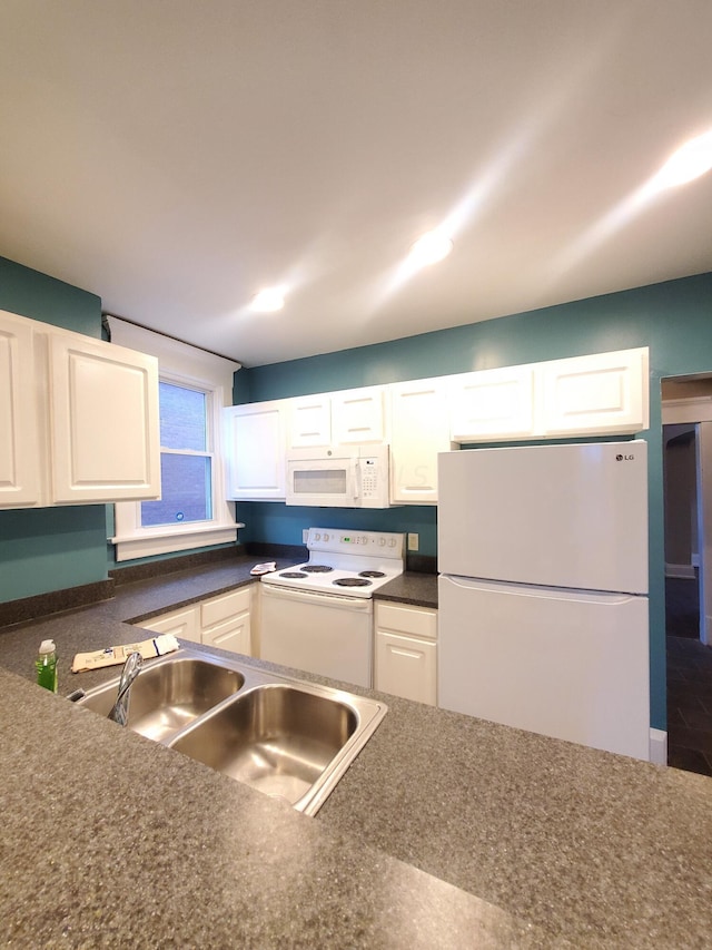 kitchen featuring white cabinetry and white appliances