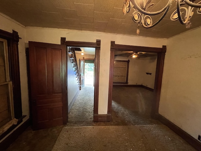 corridor with dark colored carpet and crown molding