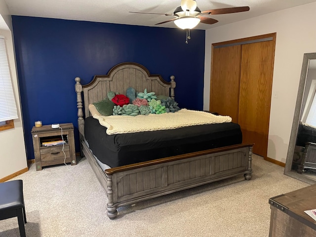 carpeted bedroom with ceiling fan and a closet