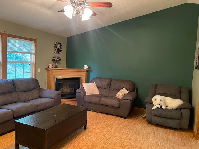 carpeted living room featuring a textured ceiling, ceiling fan, and vaulted ceiling