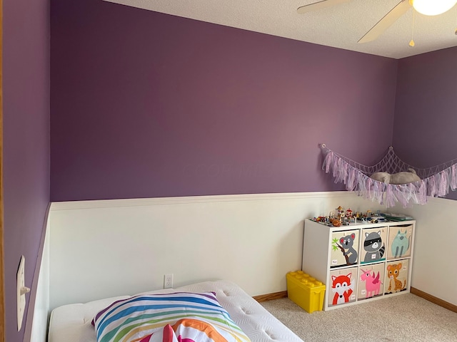 bedroom featuring carpet flooring, ceiling fan, and a textured ceiling