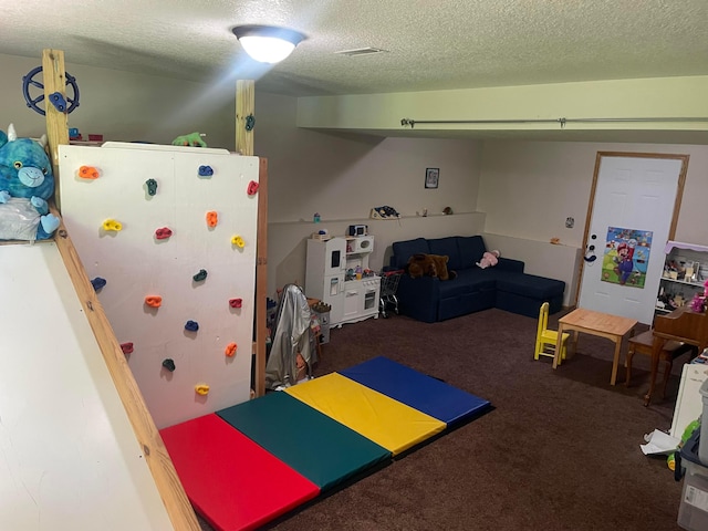 playroom with carpet and a textured ceiling