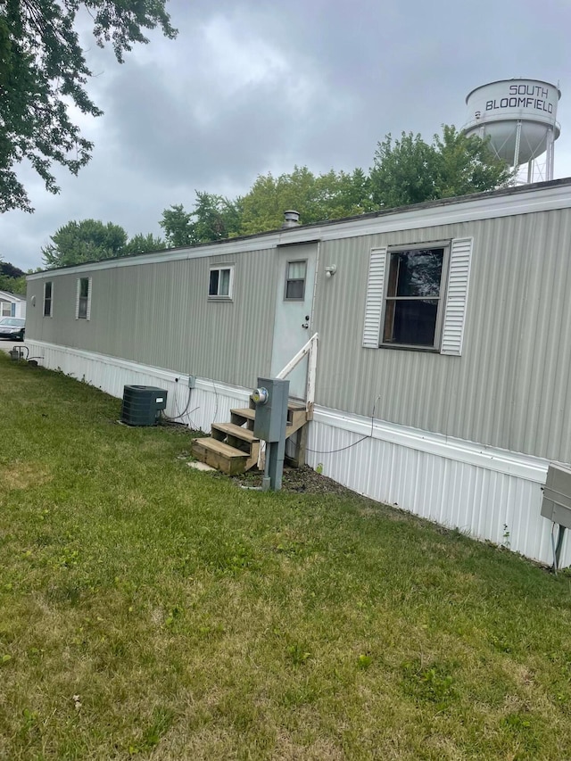 exterior space featuring a lawn and central AC unit