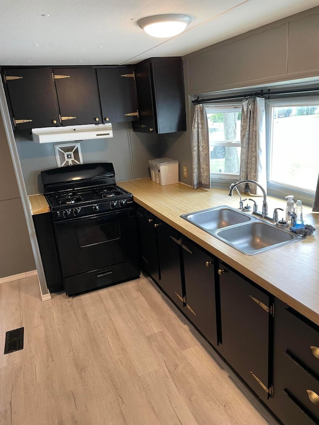 kitchen with black gas range, sink, and light hardwood / wood-style flooring