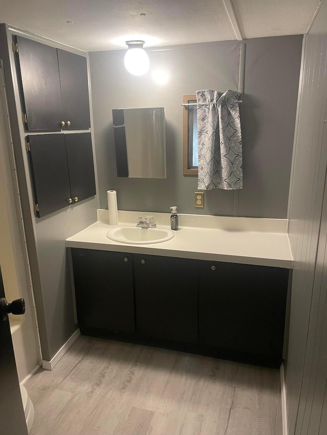 bathroom with a textured ceiling, vanity, and hardwood / wood-style flooring