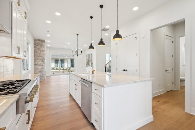 kitchen with white cabinets, a sink, visible vents, light wood-style floors, and appliances with stainless steel finishes
