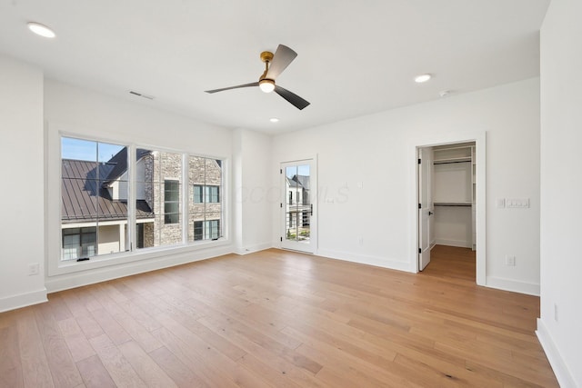 unfurnished bedroom featuring baseboards, a ceiling fan, visible vents, and light wood-style flooring