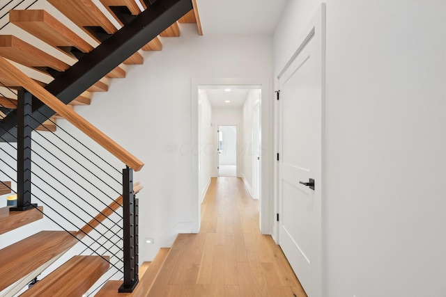 hallway featuring recessed lighting, light wood-type flooring, and stairway