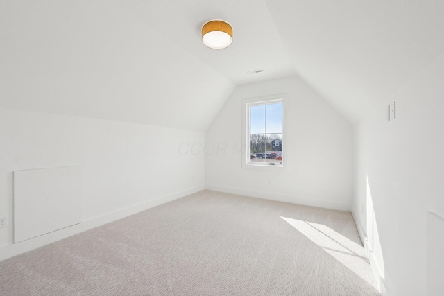 bonus room with lofted ceiling, light carpet, and baseboards