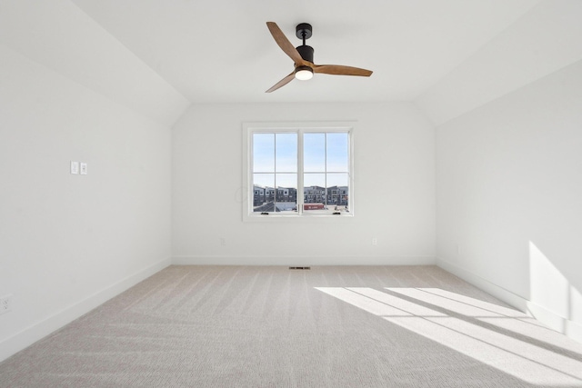unfurnished room with lofted ceiling, visible vents, light colored carpet, and ceiling fan