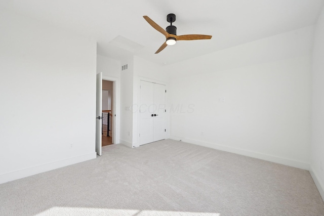 unfurnished bedroom with a closet, ceiling fan, light carpet, baseboards, and visible vents