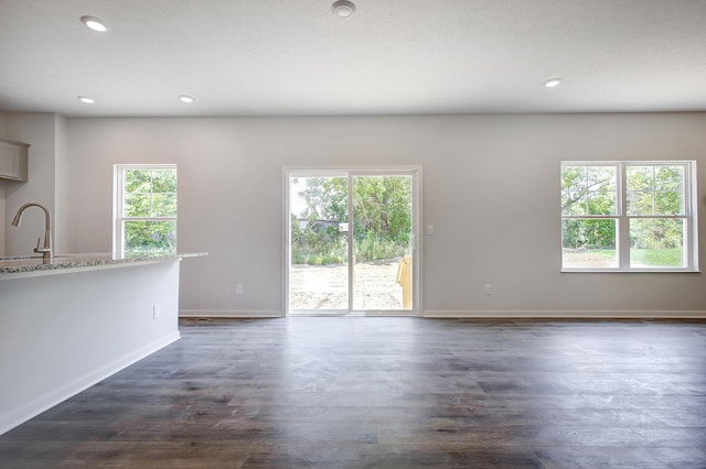 unfurnished living room with sink and dark hardwood / wood-style floors