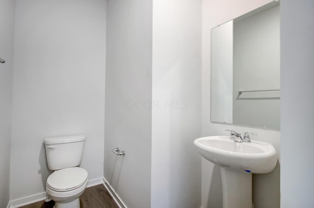 bathroom featuring hardwood / wood-style flooring and toilet