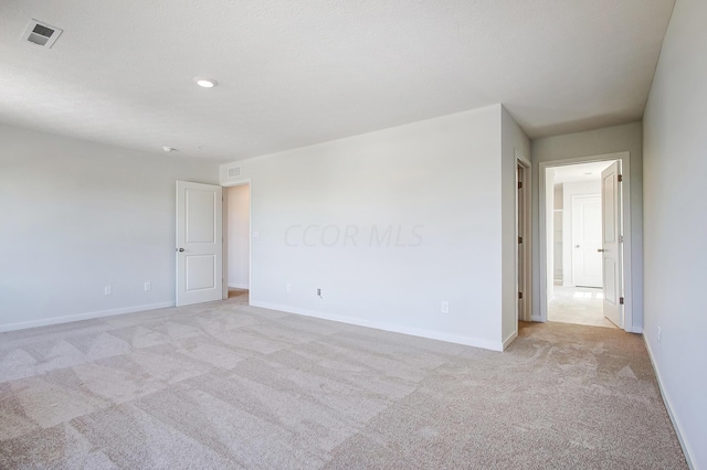 unfurnished room featuring light carpet