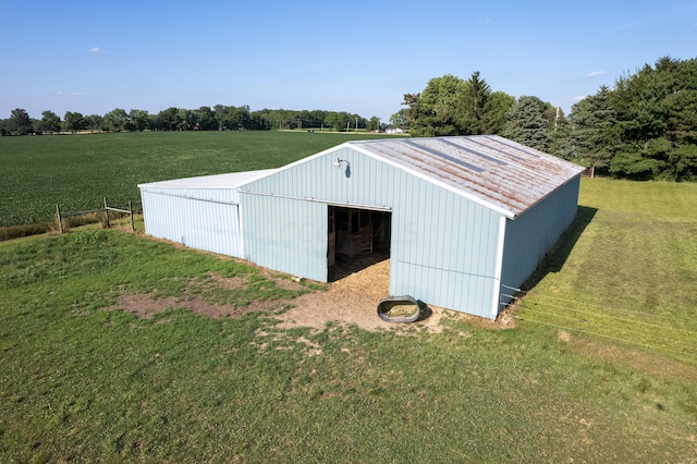 view of outdoor structure with a rural view and a lawn