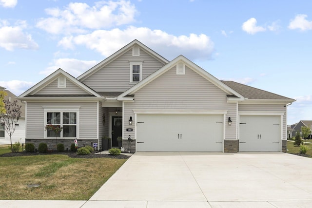 craftsman-style house featuring a front lawn and a garage