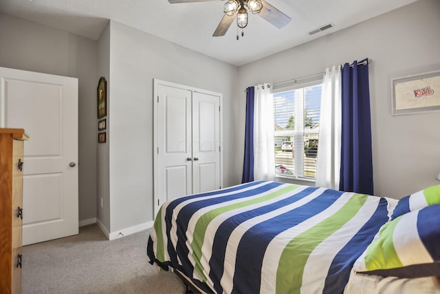 carpeted bedroom with ceiling fan and a closet