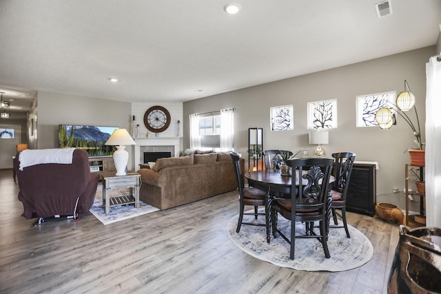 dining space featuring hardwood / wood-style floors and a tiled fireplace