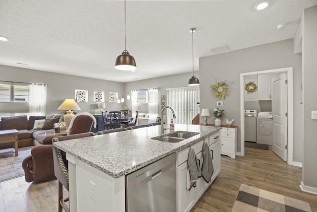 kitchen with white cabinets, a center island with sink, stainless steel dishwasher, and sink